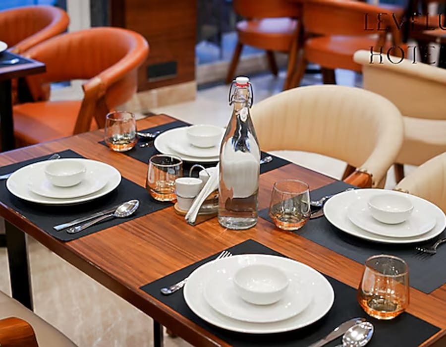 A table laid for a meal at the restaurant in White Panda Hotel Divine Peaks, with plates, glasses