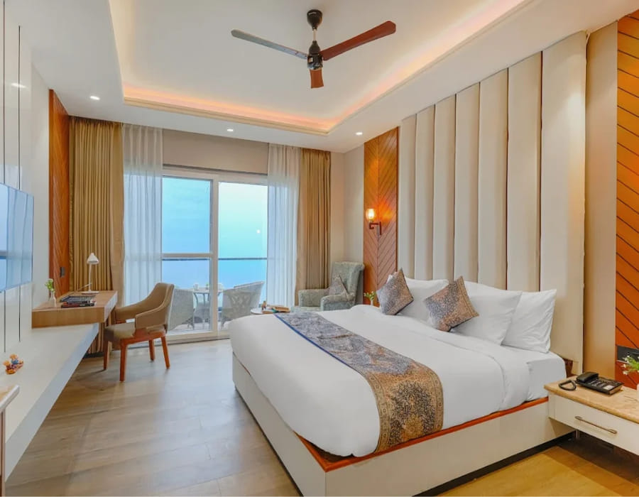 The Premium Room with Balcony at White Panda Hotel Divine Peaks, with the bed against fluted panelling and a table
