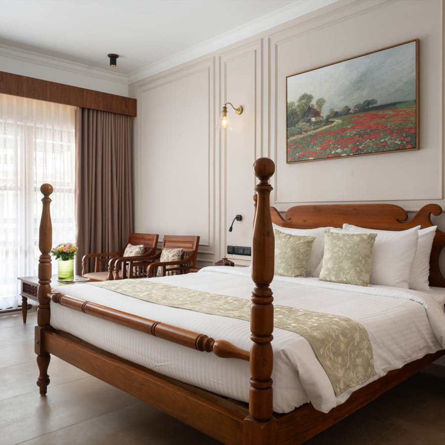 Pool View Room four-poster king bed with open balcony doors framing tropical greenery, Sanskreti