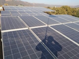 Solar panels on the camp roof, with the Aravallis behind