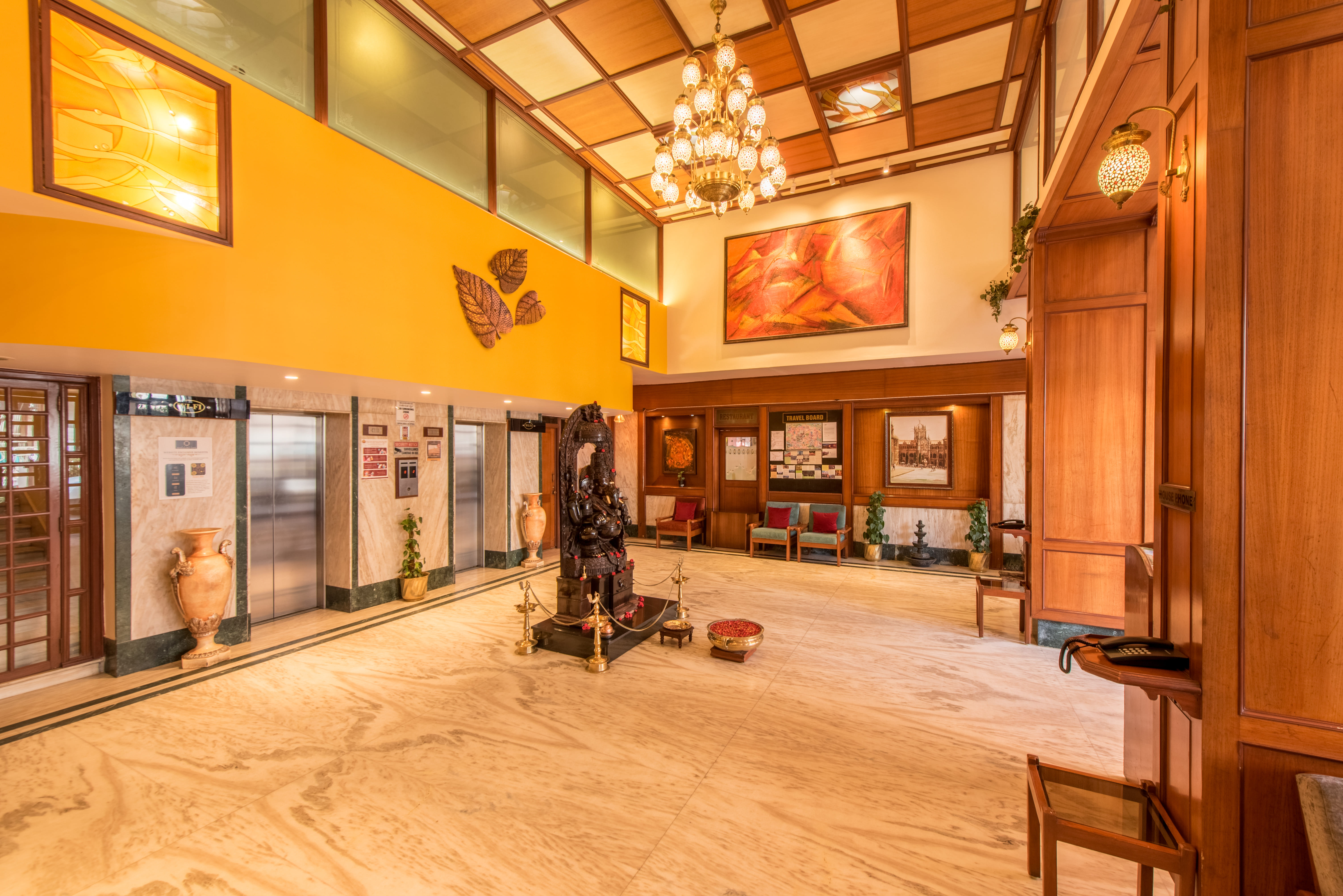 Grand lobby of Bangalore Gate Hotel, chandelier, Ganesha idol, and heritage paintings