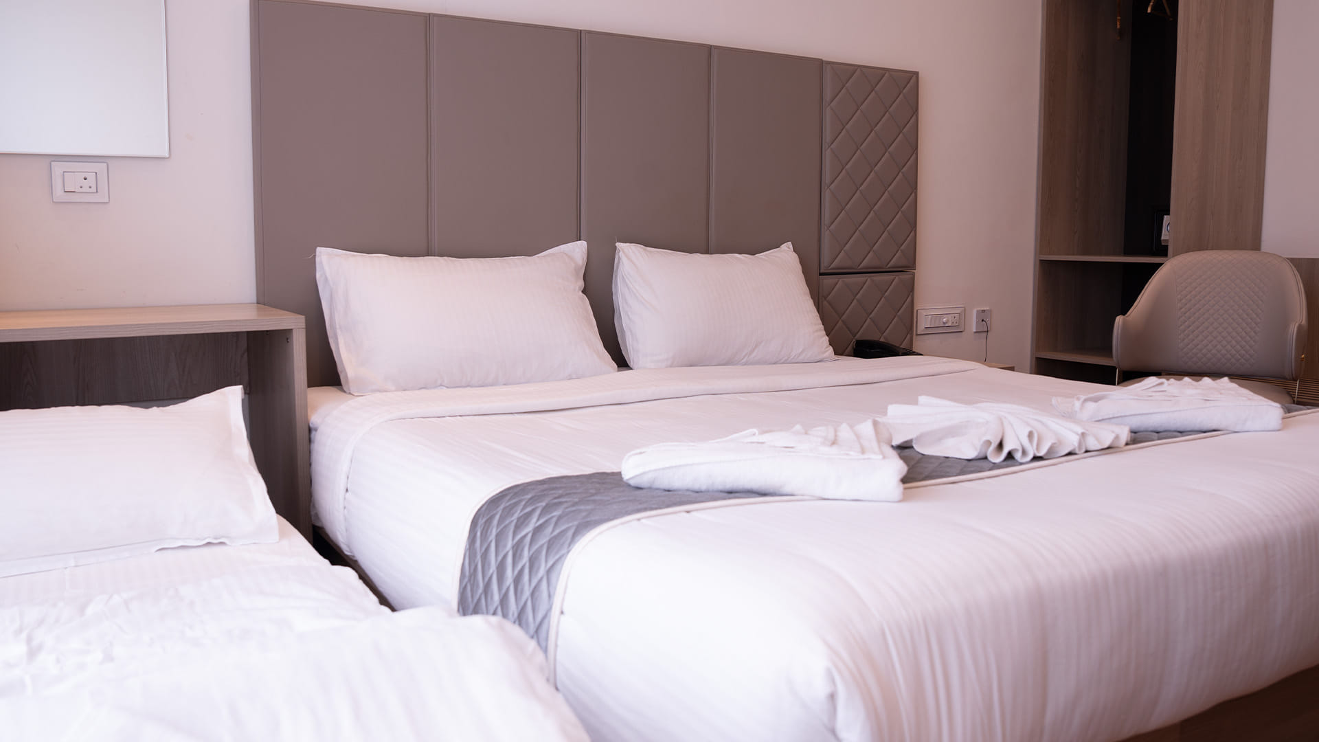 Royal King Room with a king bed, an additional single bed, and a wall-mounted television