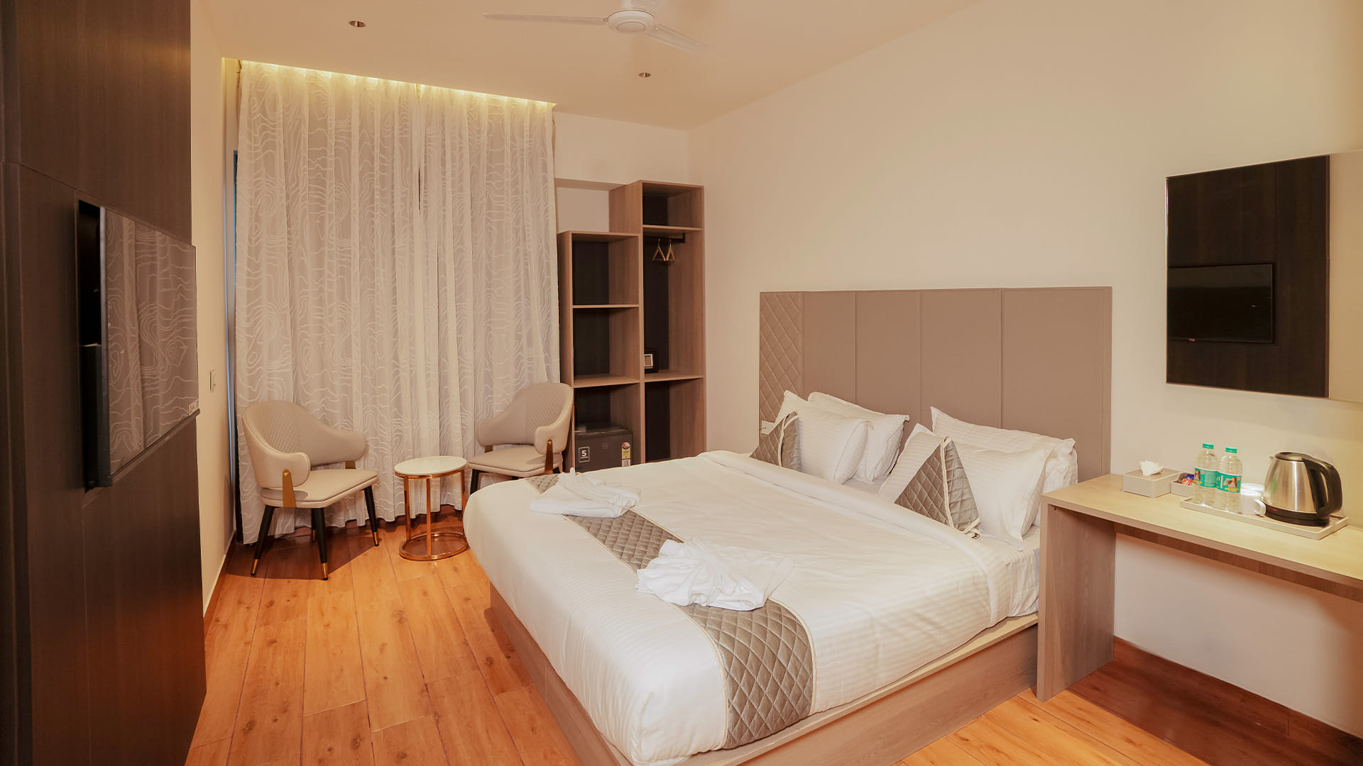 Royal King Room with a king bed, open wardrobe shelving, and a wall-mounted television