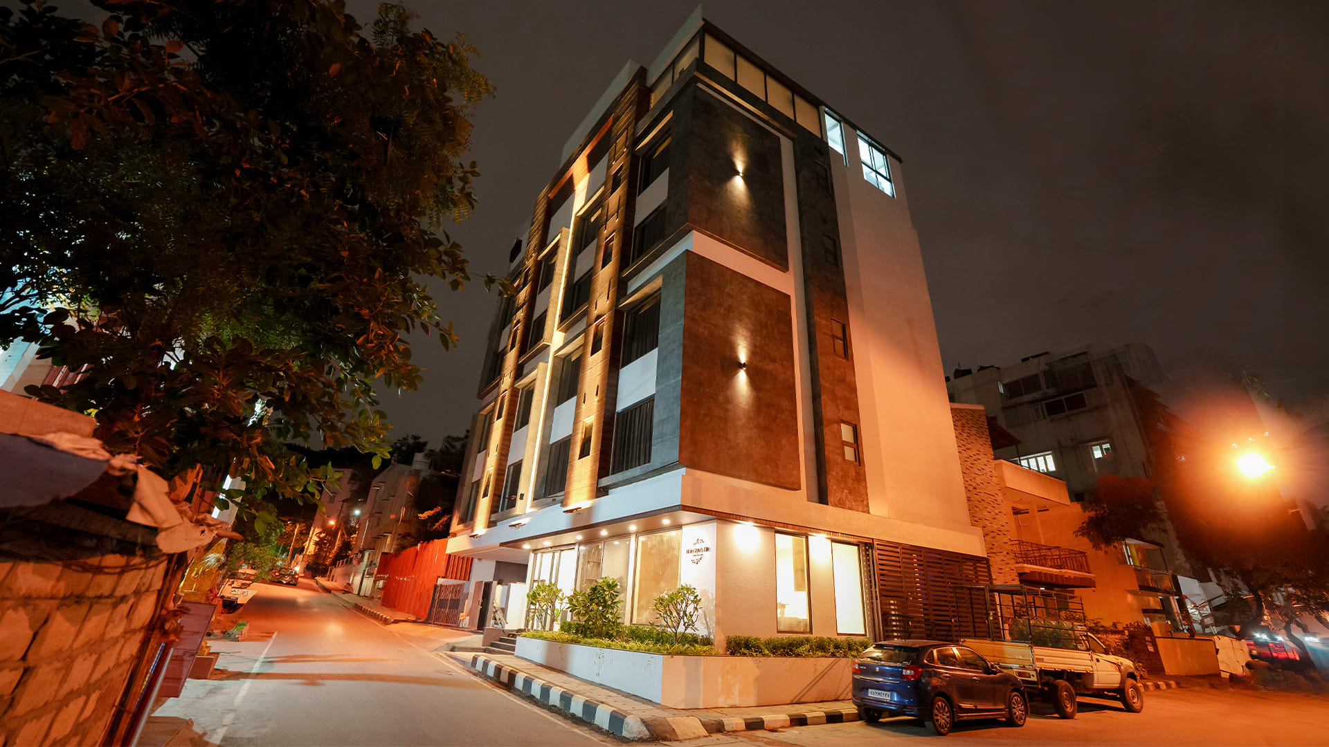 Night view of Hotel Ritvi's Elite lit up on the street corner