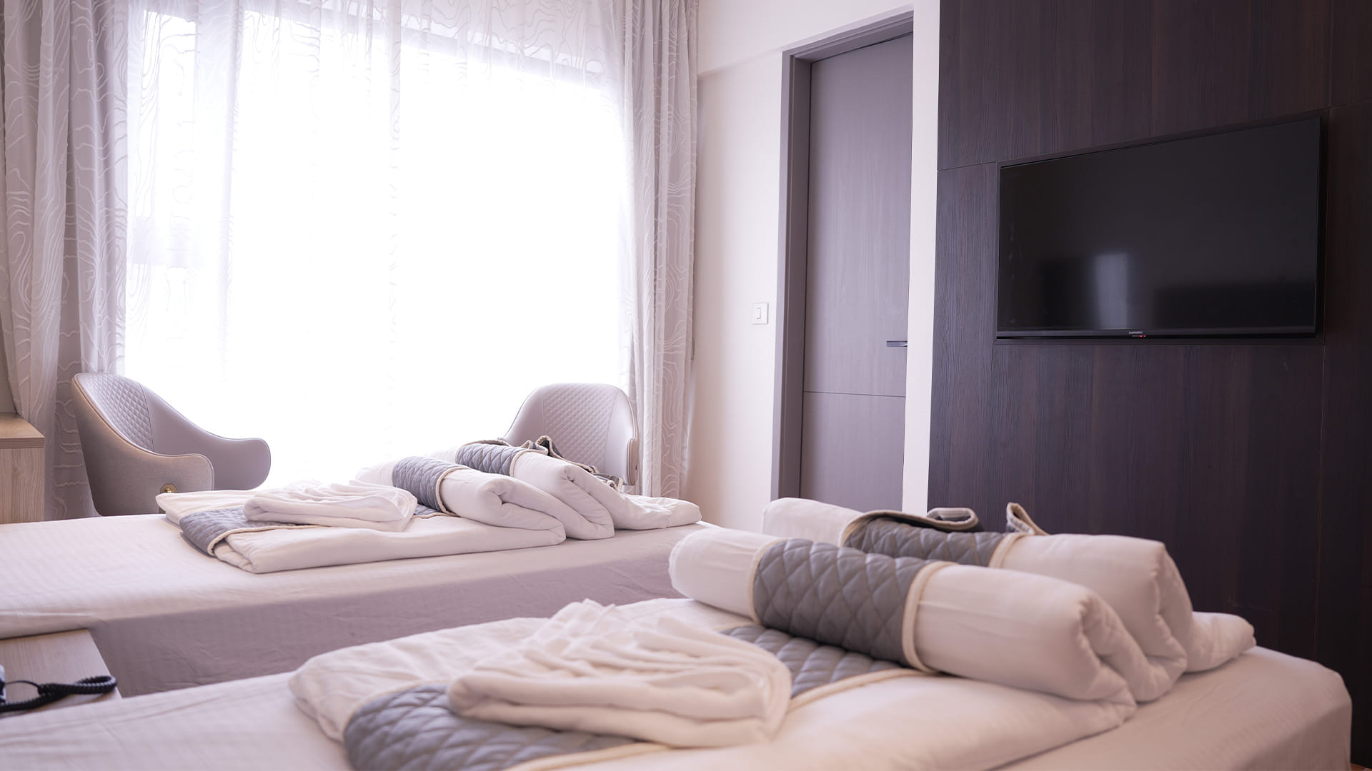 Executive Twin Room with two beds facing a wall-mounted television