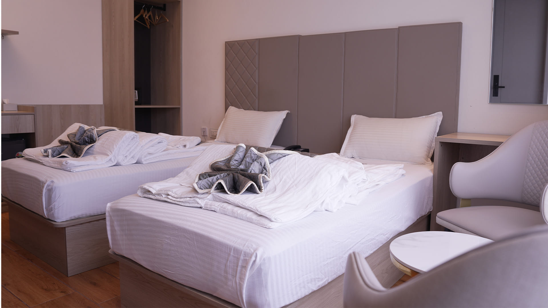Executive Twin Room with two beds and an open wardrobe with hangers
