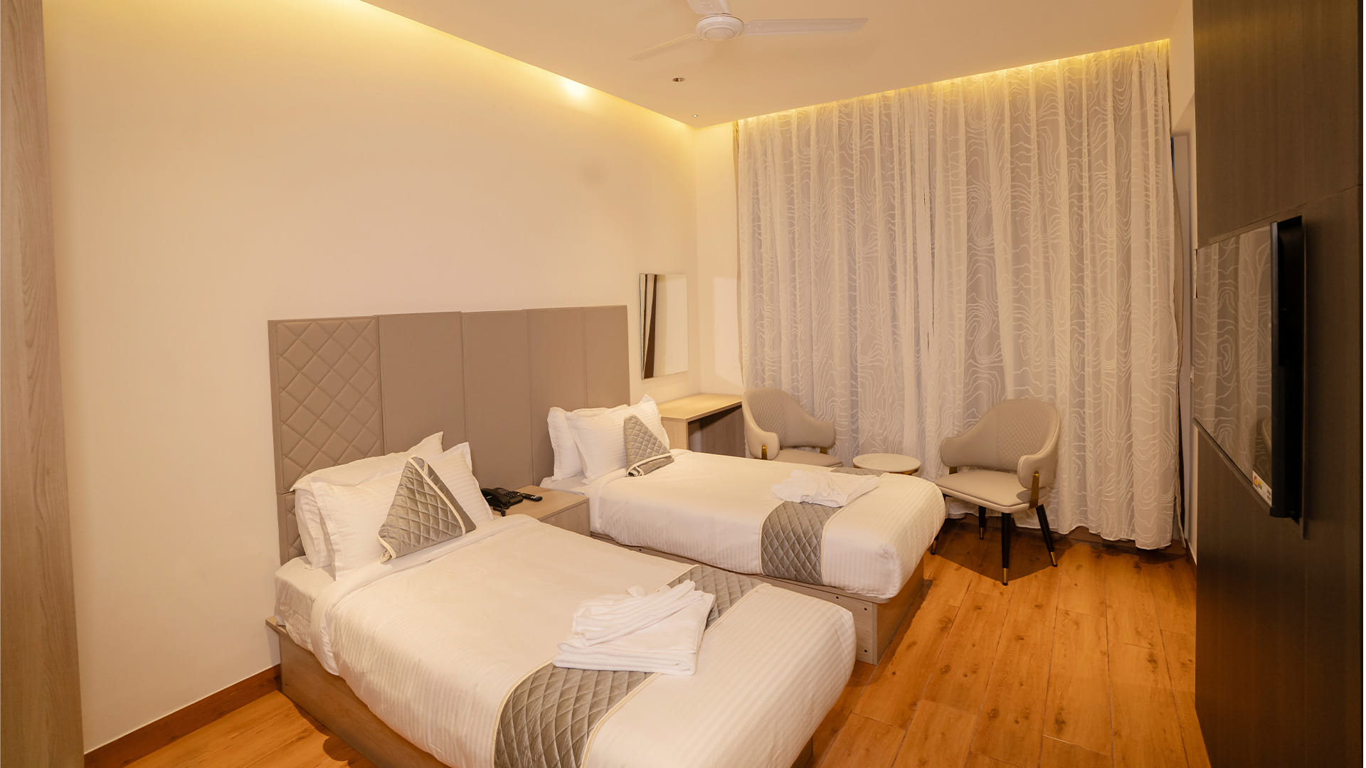 Executive Twin Room with two beds, a work desk, and a wall-mounted television