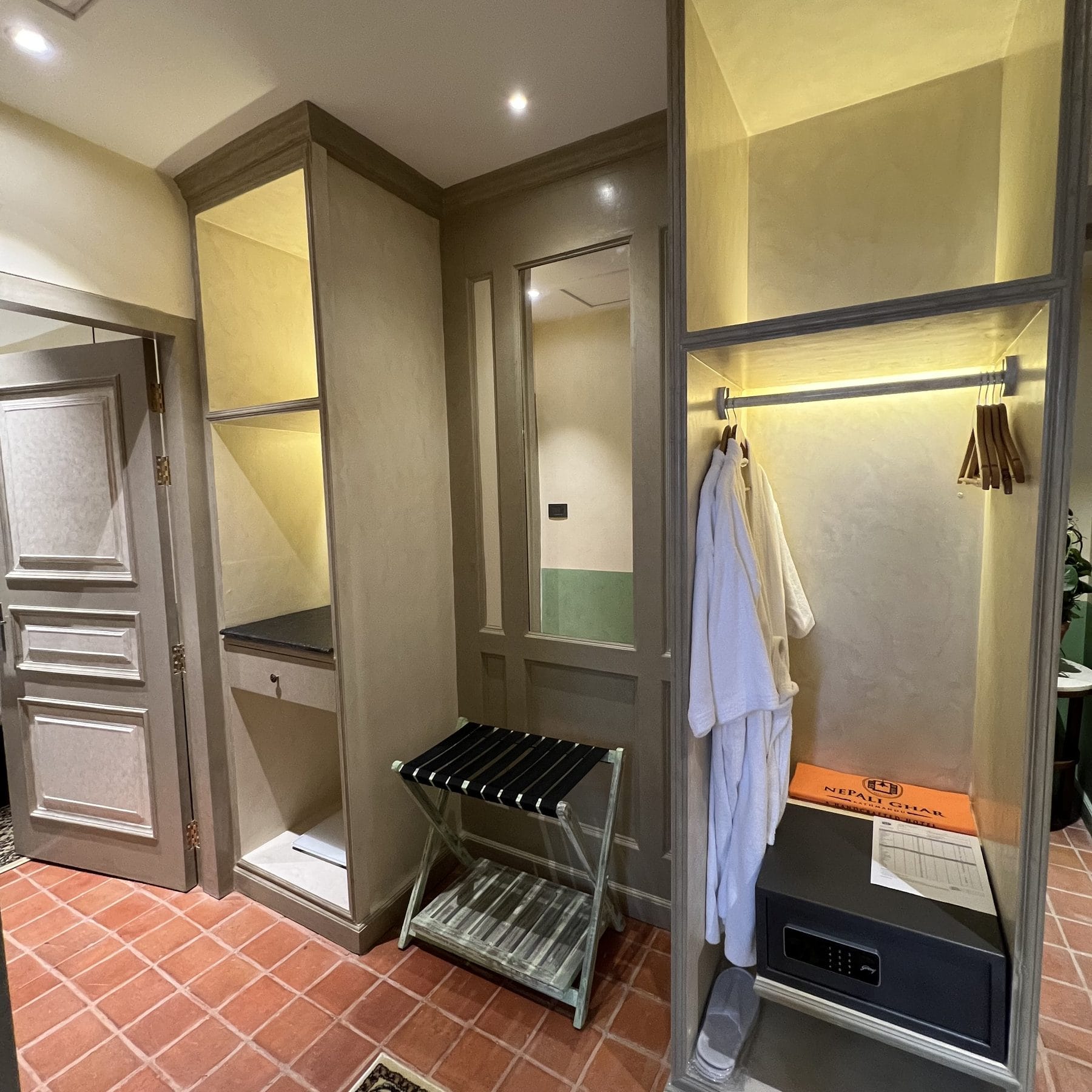 The wardrobe in the Classic Junior Suite at Nepali Ghar Hotel, hung with bathrobes and fitted with a safe and luggage rack for guests on longer stays here.