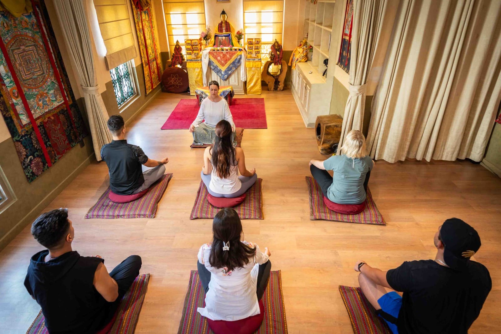 Guests seated in silent meditation before the Buddhist shrine at the Himalayan Buddhist Meditation Center, the daily morning yoga venue at Nepali Ghar Hotel.