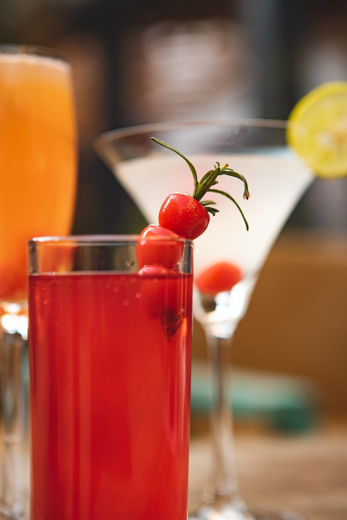 A signature cocktail at Jharana Bar, the outdoor cocktail bar of Nepali Ghar Hotel, garnished with maraschino cherries and a sprig of fresh rosemary on top.