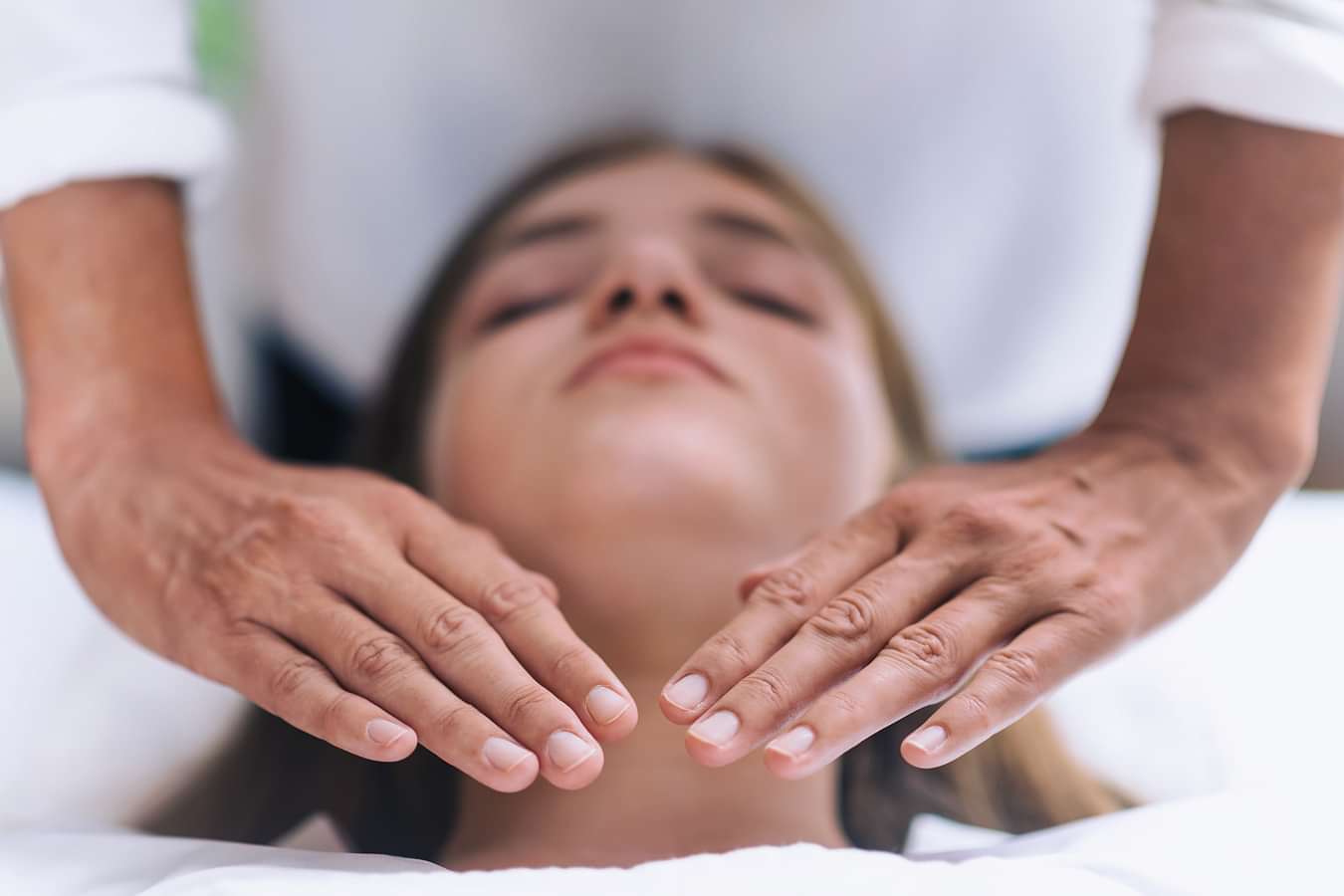 A woman in a white robe receiving a facial massage at YO1, Catskills, New York, highlighting relaxation and skincare treatments.