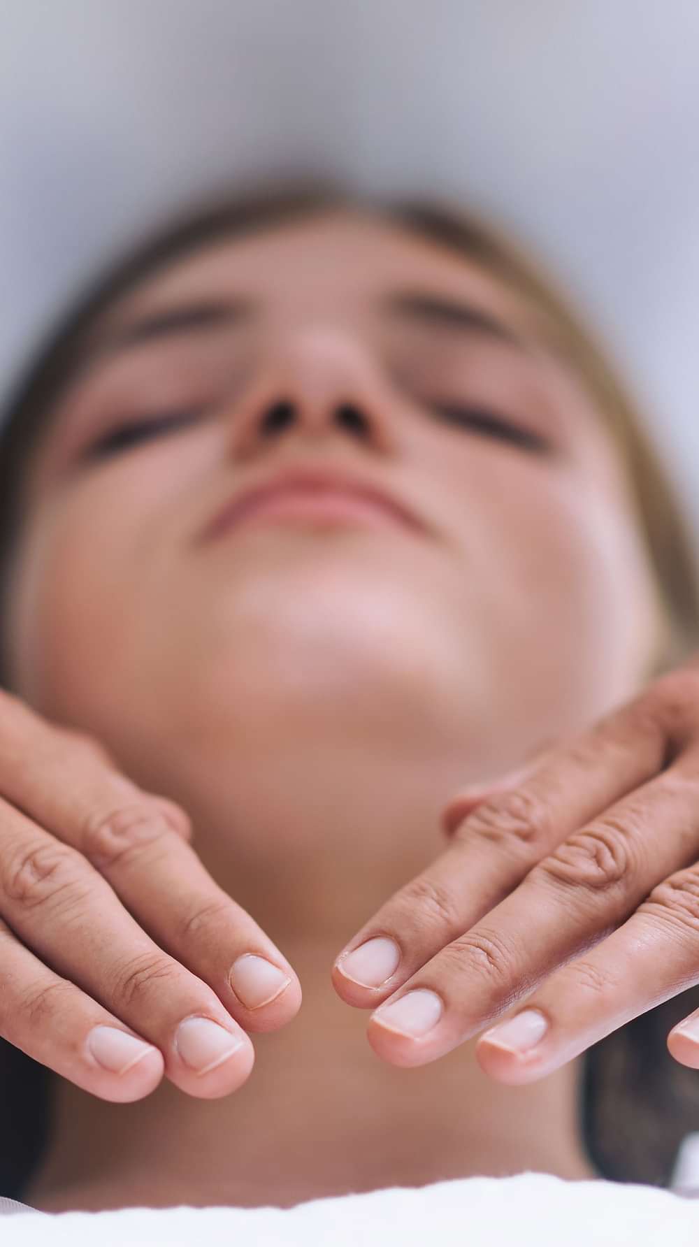 A woman in a white robe receiving a facial massage at YO1, Catskills, New York, highlighting relaxation and skincare treatments.