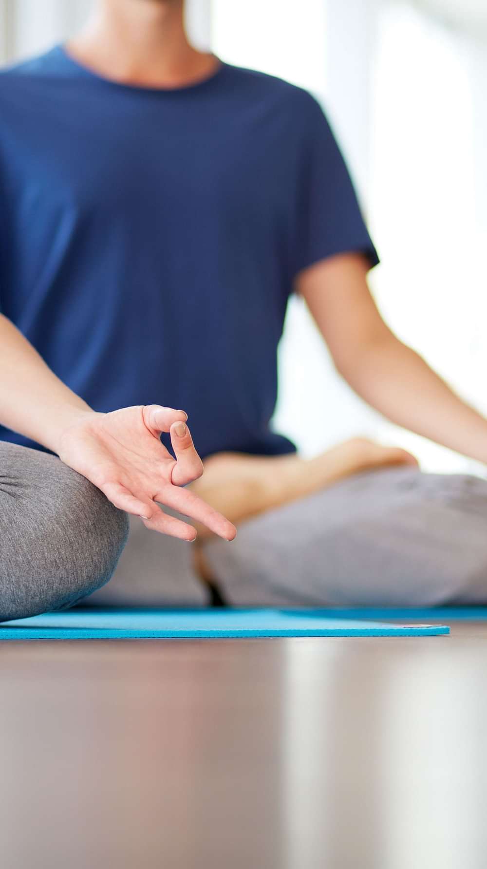 Two individuals practicing yoga meditation at YO1, Catskills, New York, with focus on mindfulness and inner peace.