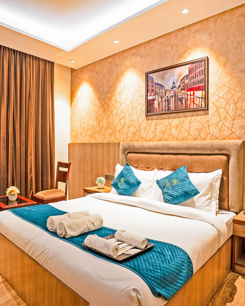 A king bed in a Superior King room, with a work desk and curtained window