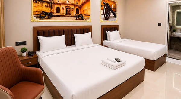 Jal Mahal Family Room with a double bed, a single bed and an armchair at Lime Tree Hotel & Banquet, Jaipur