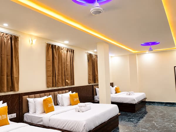 Family Suite beds under a ceiling fan and cove lights at Lime Tree Hotel, Vrindavan