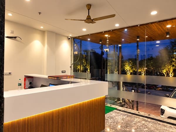 Reception desk with a glass front and garden view at Lime Tree Hotel, Vrindavan