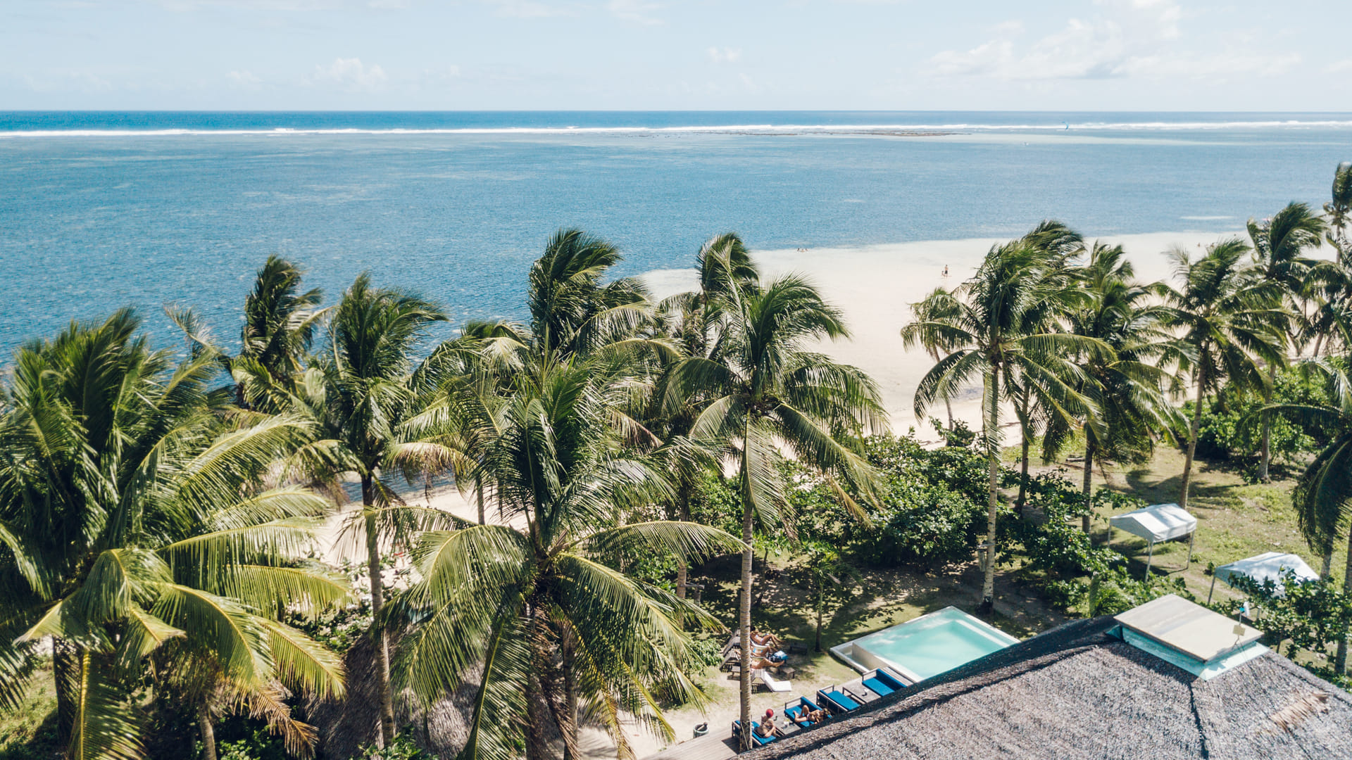 Aerial drone view of Bravo Beach Resort Siargao's thatched-roof grounds and coastline