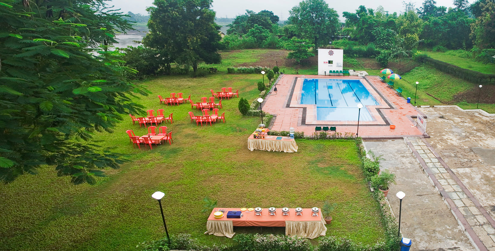 Poolside party lawn set with dining tables and buffet counters beside the swimming pool at VITS Kamats Resort Silvassa