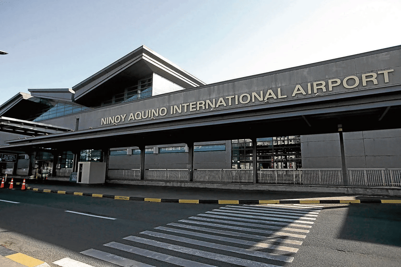 Exterior facade of Ninoy Aquino International Airport terminal building with signage, from a news article on border reopening