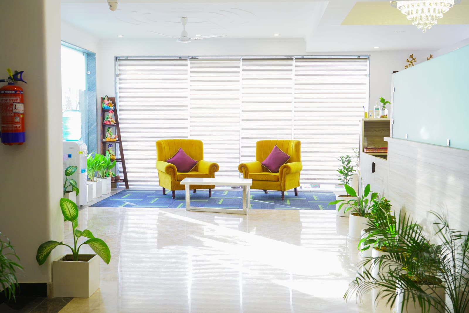 Bright lobby lounge with two yellow armchairs and indoor plants at Lime Tree Hotel, Pulkit