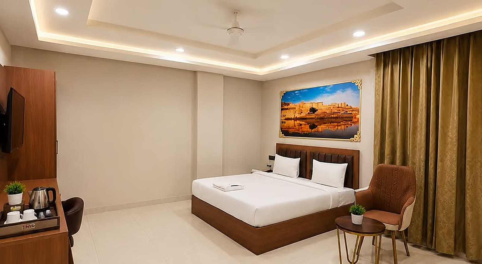 Jal Mahal Deluxe Room with a king bed, seating corner and tea set at Lime Tree Hotel & Banquet, Jaipur
