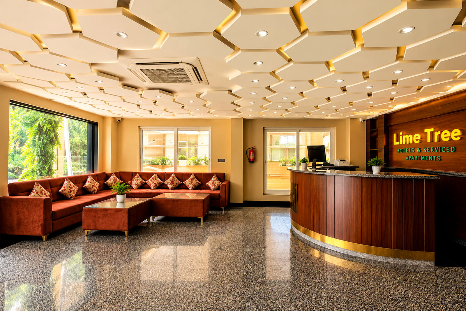Lobby and reception desk with maroon sofas at Lime Tree Hotel & Banquet, Jaipur