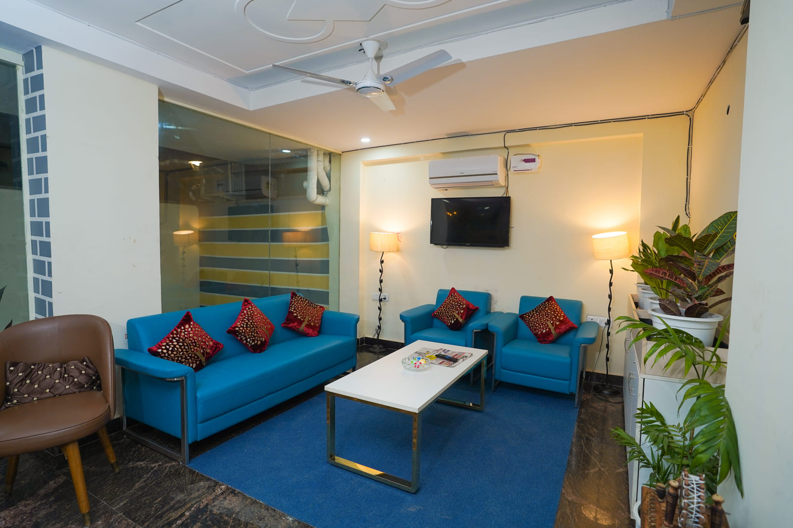 Superior King Room seating area with blue sofas and white coffee table at Lime Tree Hotel, 32nd Avenue, Gurgaon