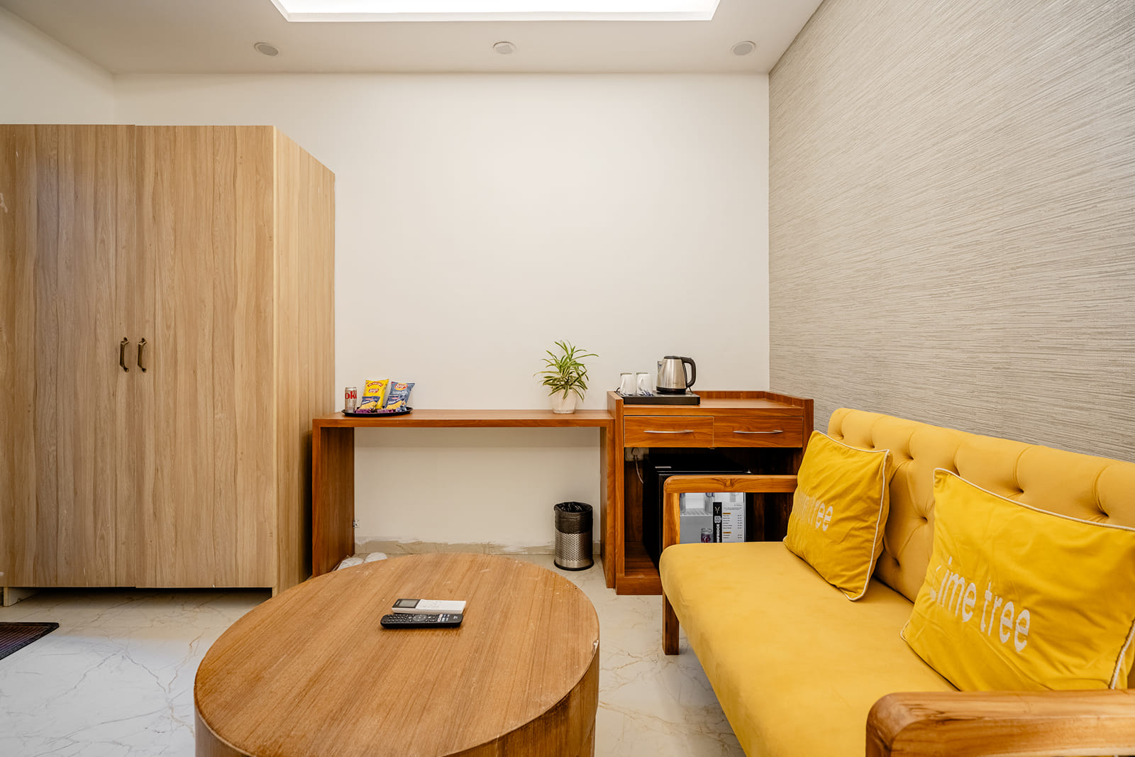Superior King Room with yellow sofa, wardrobe, tea station and bed at Lime Tree Hotel Near India Expo Mart, Greater Noida