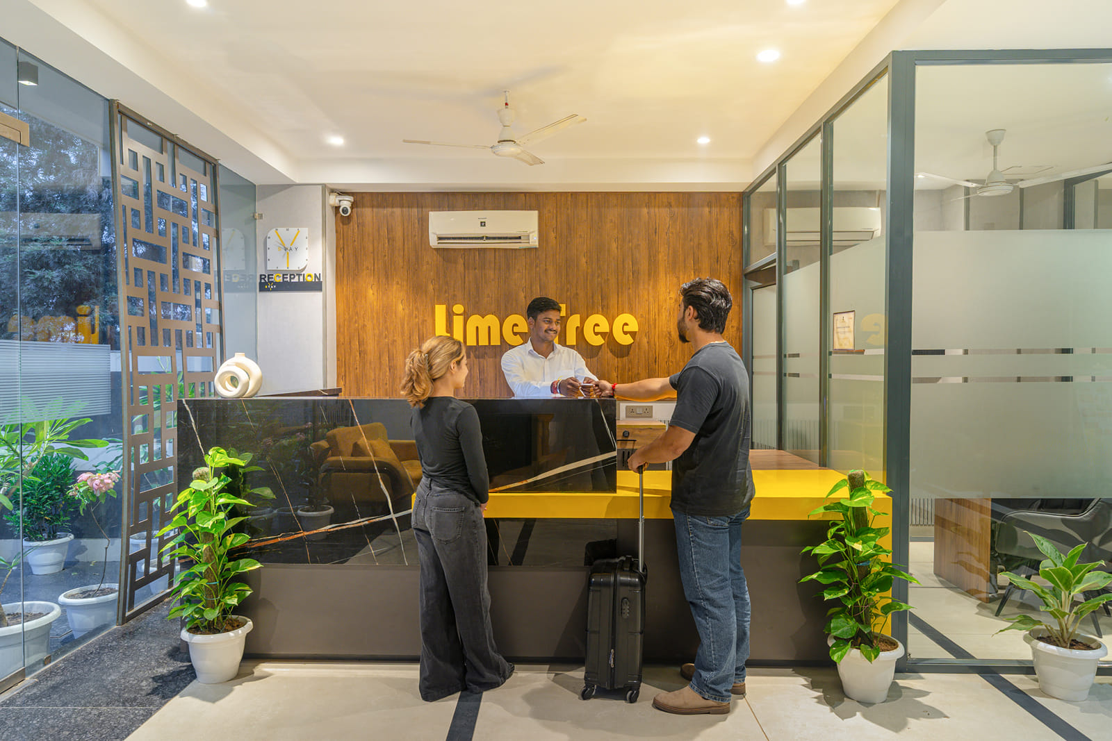 Guests checking in at the reception desk with staff behind the counter at Y Stay by Lime Tree Hotels, Greater Noida
