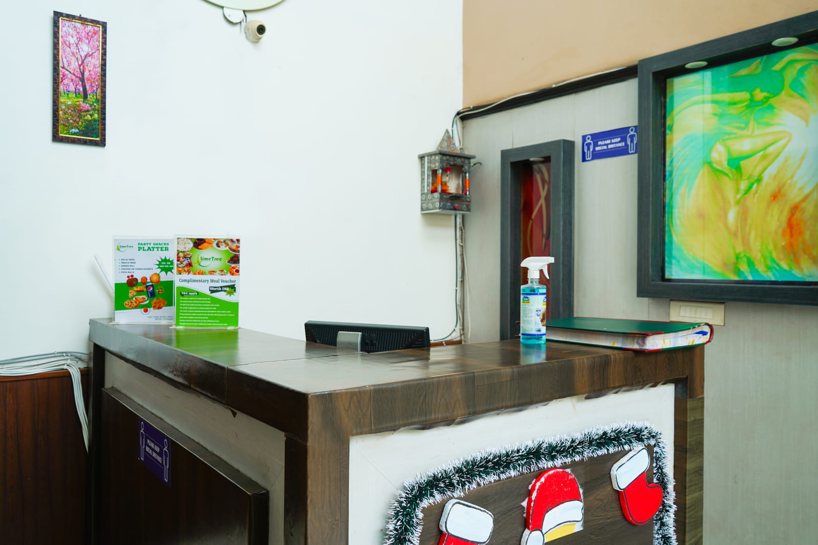Reception desk with brochures and wall art in the lobby at Lime Tree Hotel, IFFCO Chowk