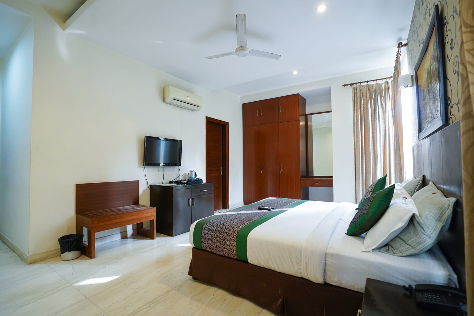 Standard Room with a double bed, wardrobe and wall-mounted television at Lime Tree Hotel, IFFCO Chowk, Gurgaon