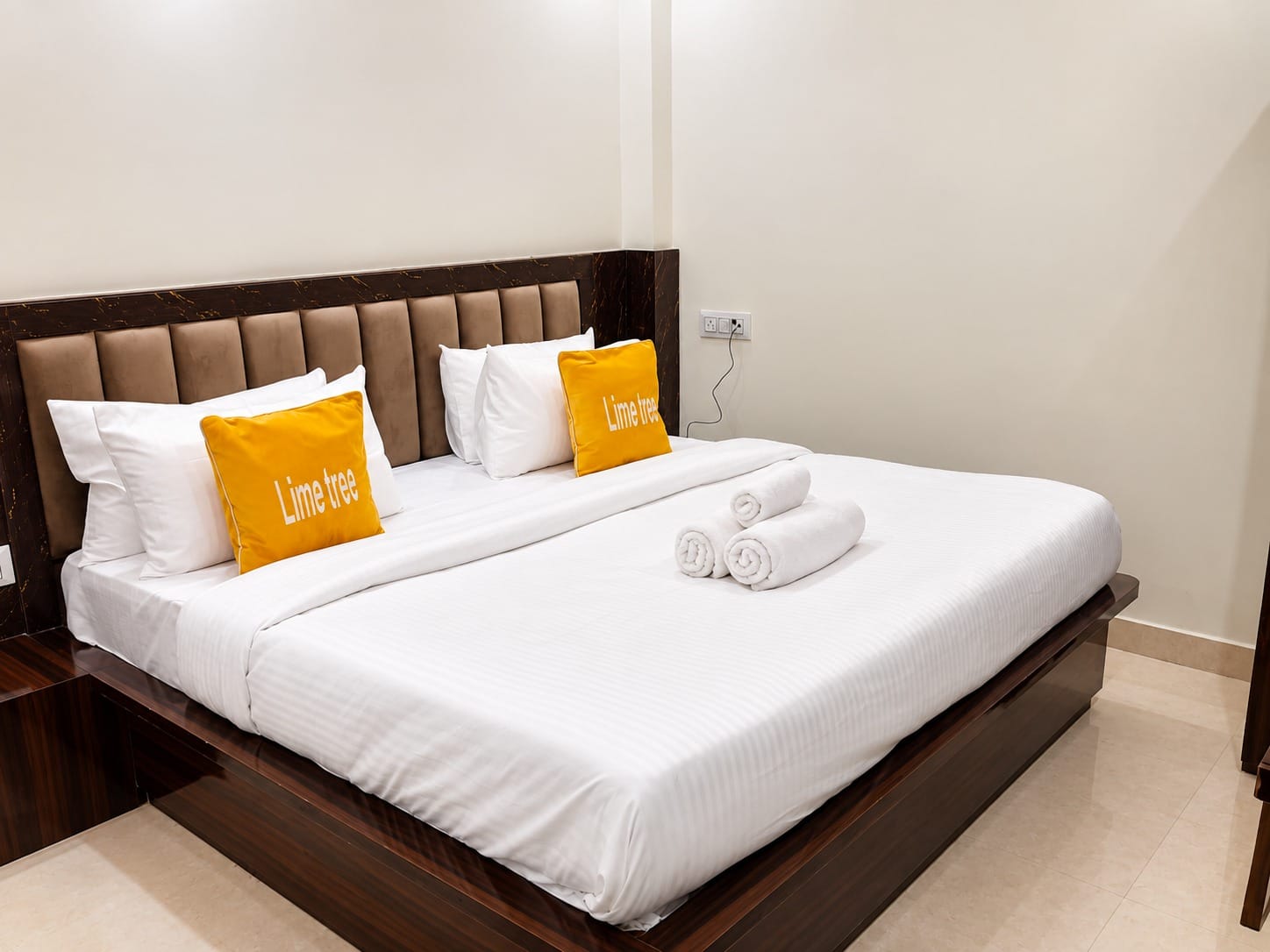 Deluxe Room king bed with white linen and towels at Lime Tree Hotel, Vrindavan