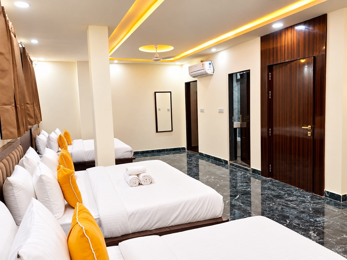 Family Suite beds with yellow cushions and a wardrobe at Lime Tree Hotel, Vrindavan