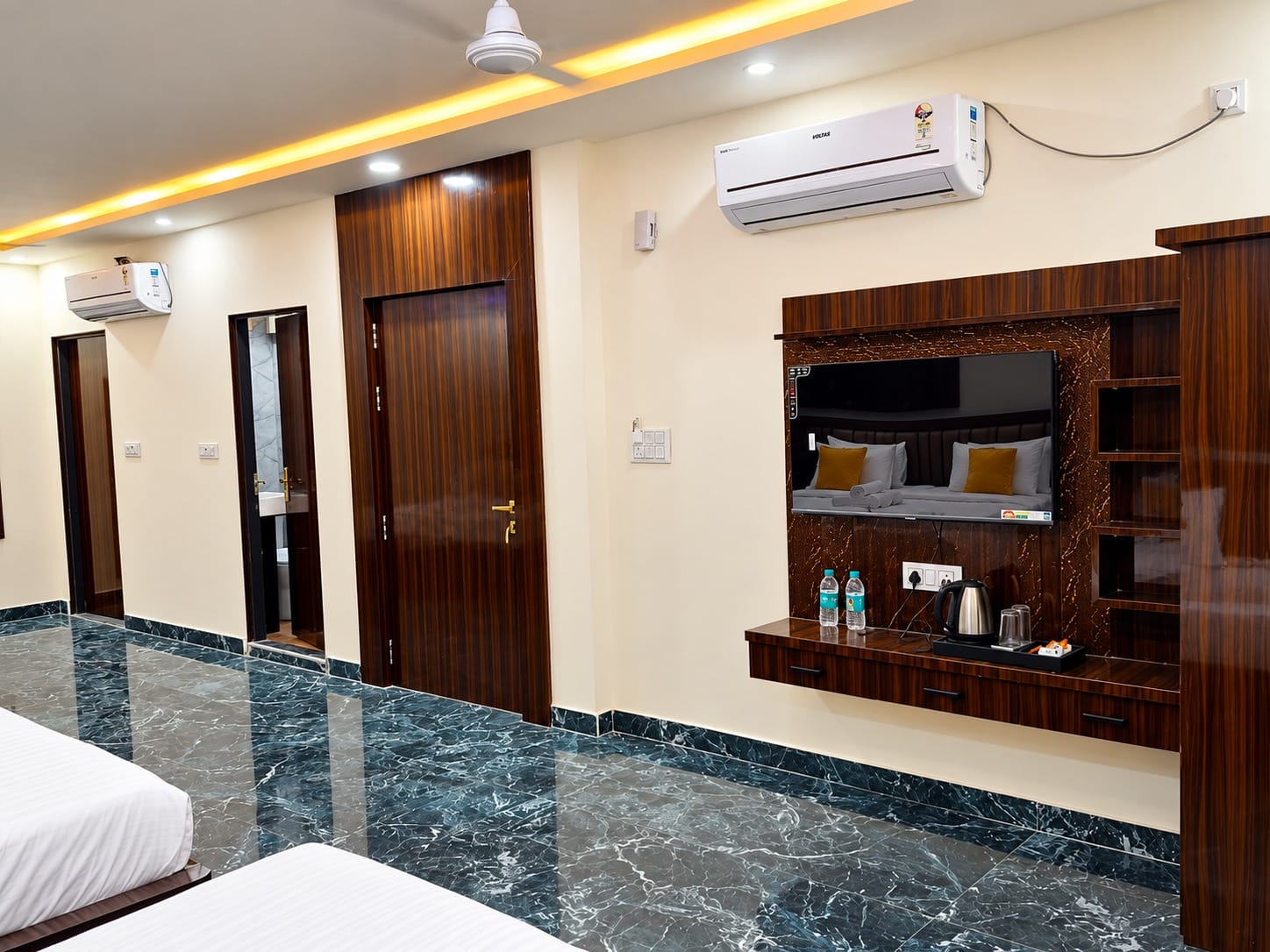 Family Suite TV unit with a kettle and water bottles at Lime Tree Hotel, Vrindavan
