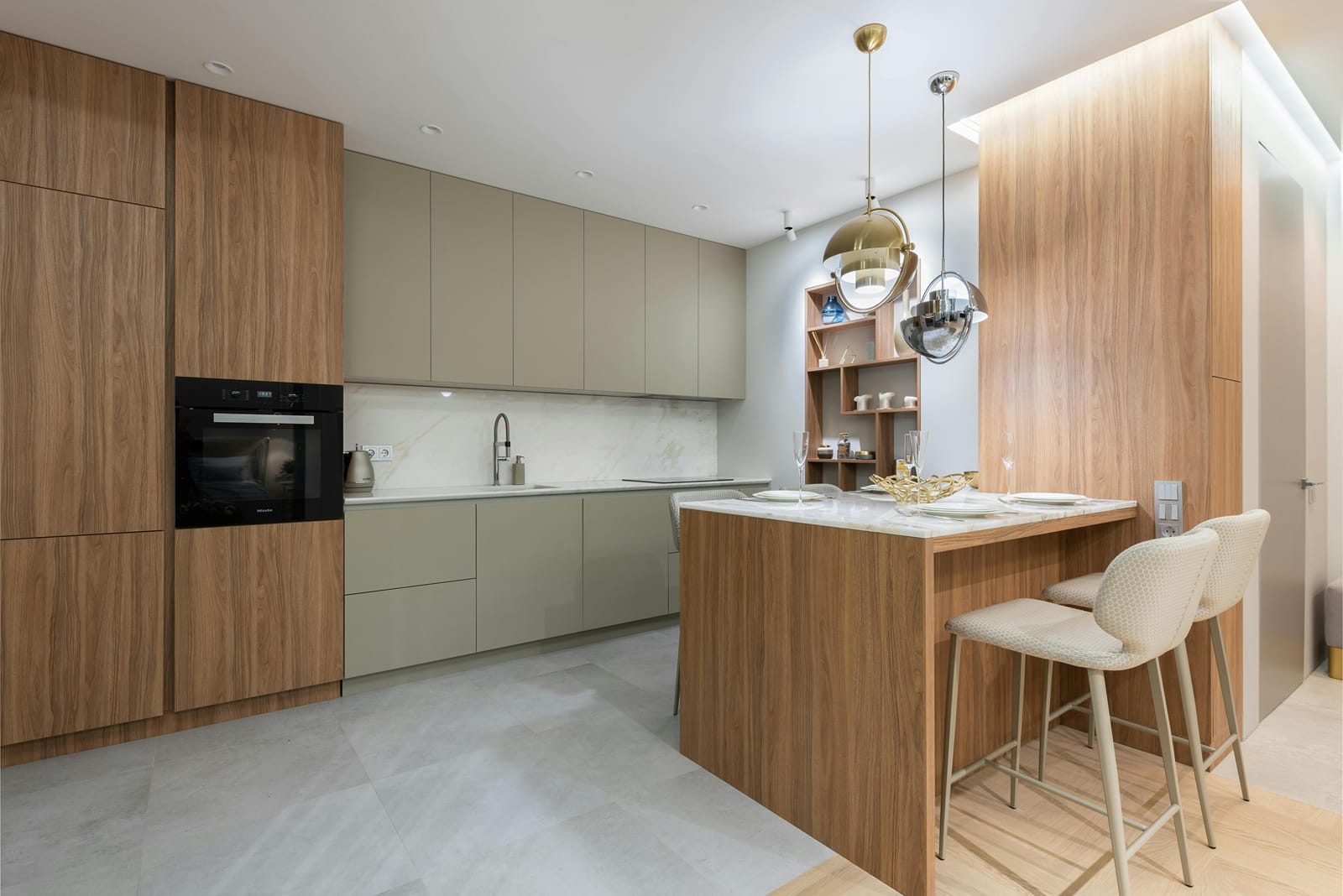 Modern kitchen with a wooden island, bar stools and built-in oven at Turmeric Stays by Lime Tree Hotel, Greater Noida