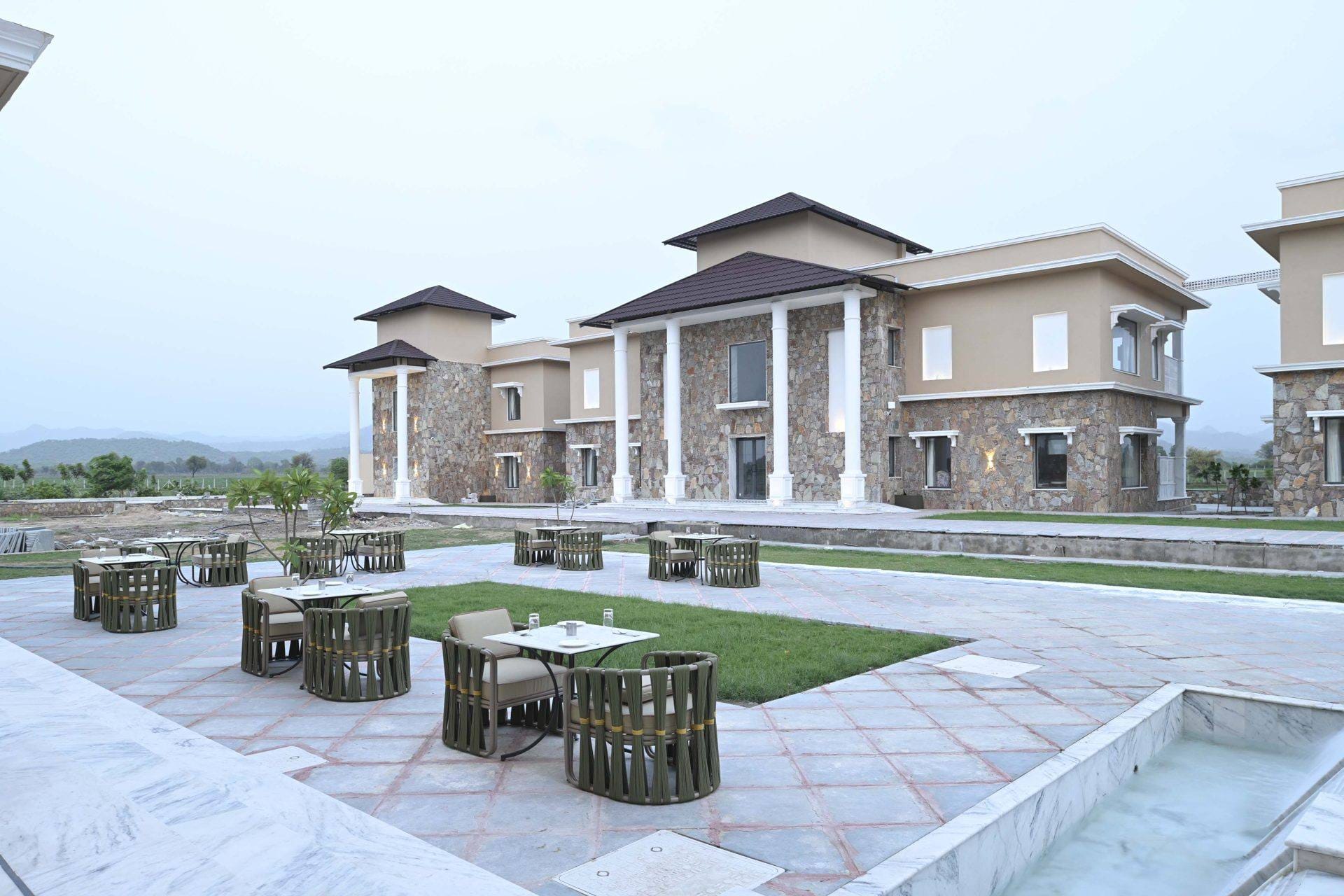 Courtyard lawn with outdoor dining tables at twilight