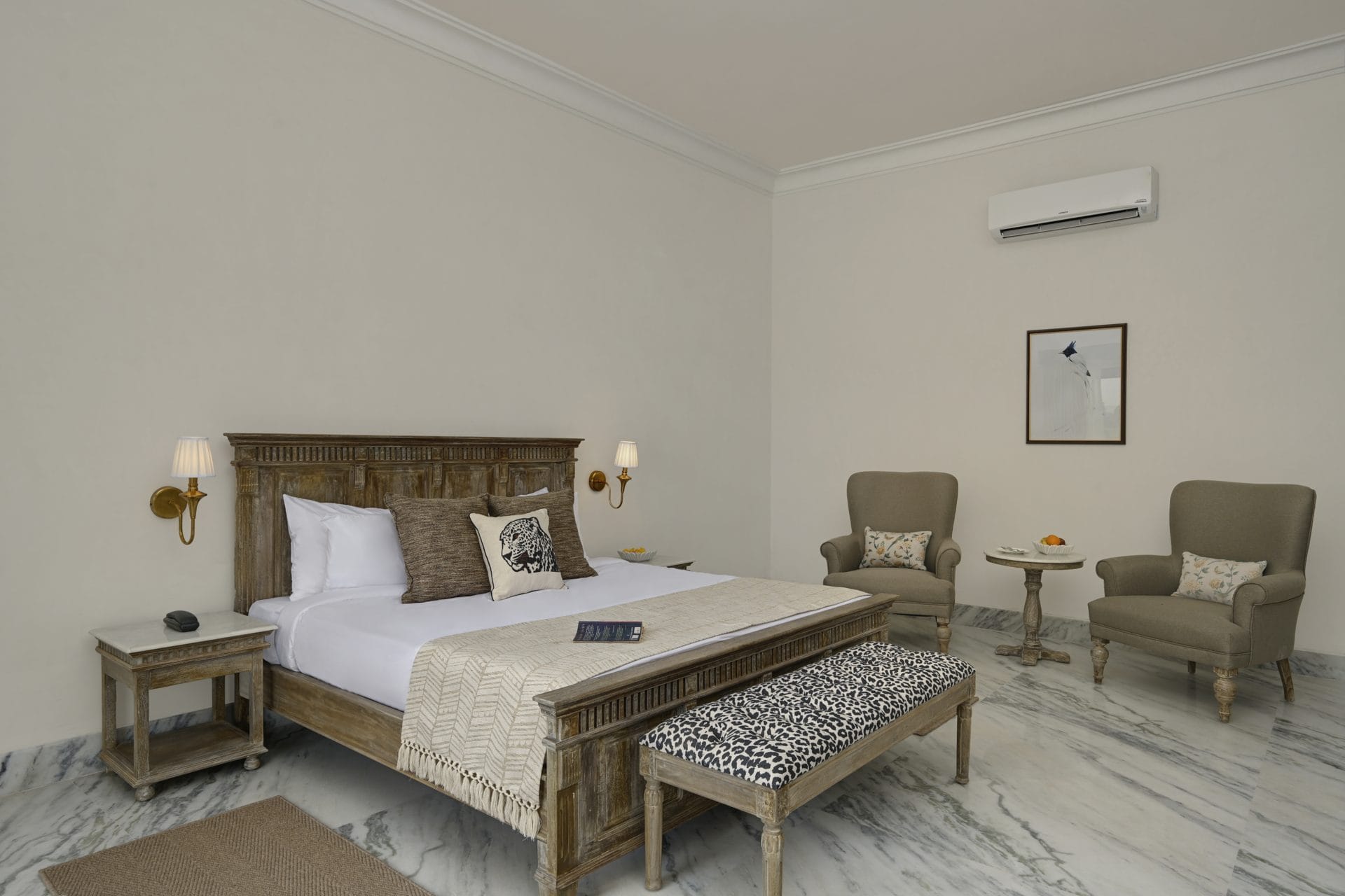 Deluxe king bed, 2 armchairs, round table, and framed art