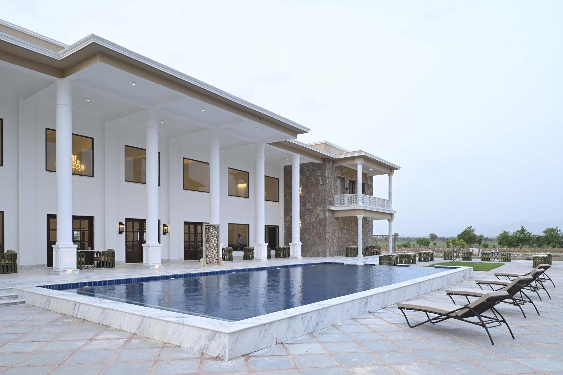 The swimming pool colonnade at dusk, seen from the facilities side