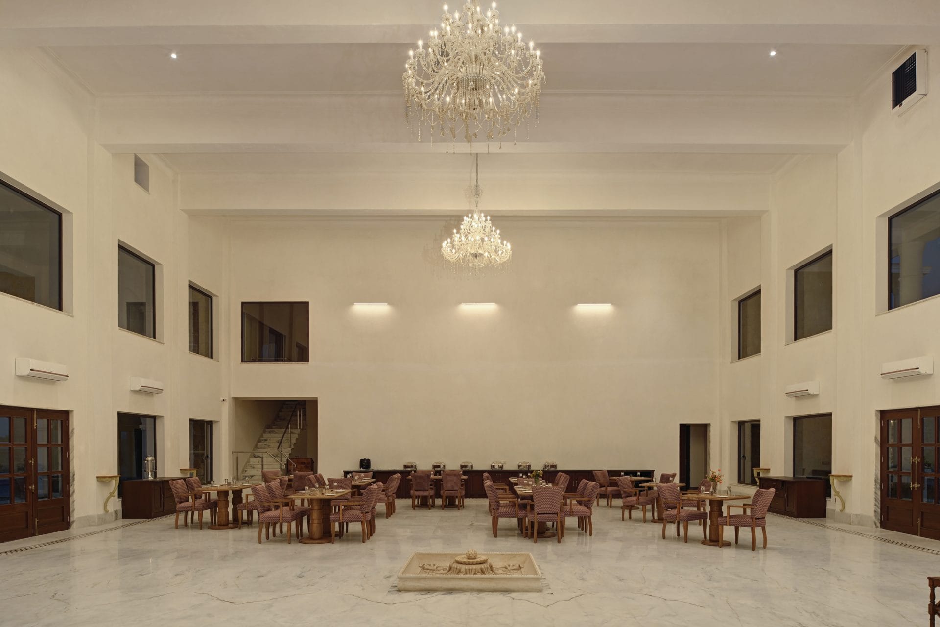 Rasa, the restaurant in Jawai, with chandeliers, round tables, and a marble floor