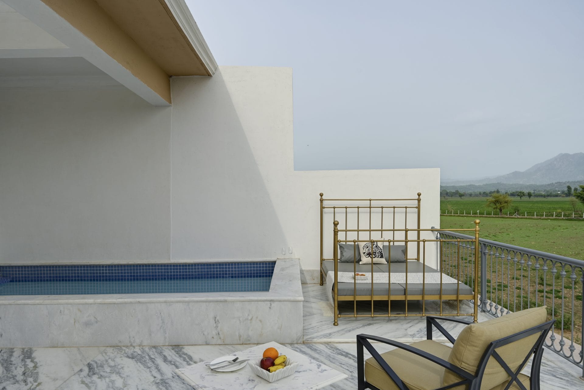 Suite plunge pool beside a brass daybed with fruit on the terrace