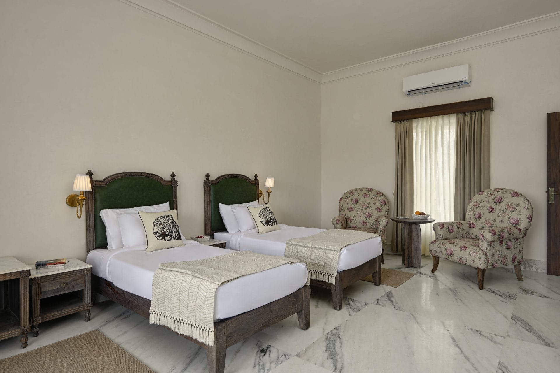 Twin Bed Room with 2 beds, floral armchairs, and a curtained window