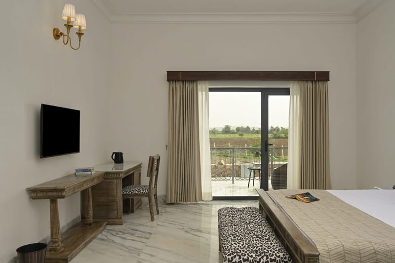 Deluxe desk, wall-mounted TV, and curtains drawn back from the balcony
