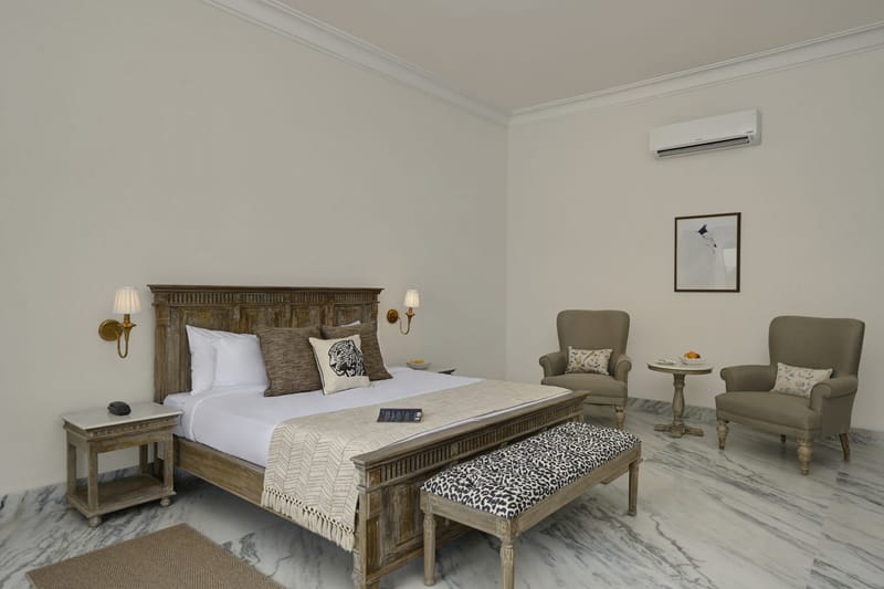 Deluxe king bed, 2 armchairs, round table, and framed art