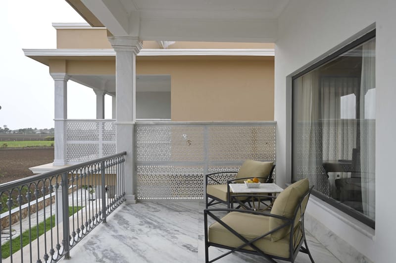 Suite balcony with iron railing, 2 chairs, and a small table