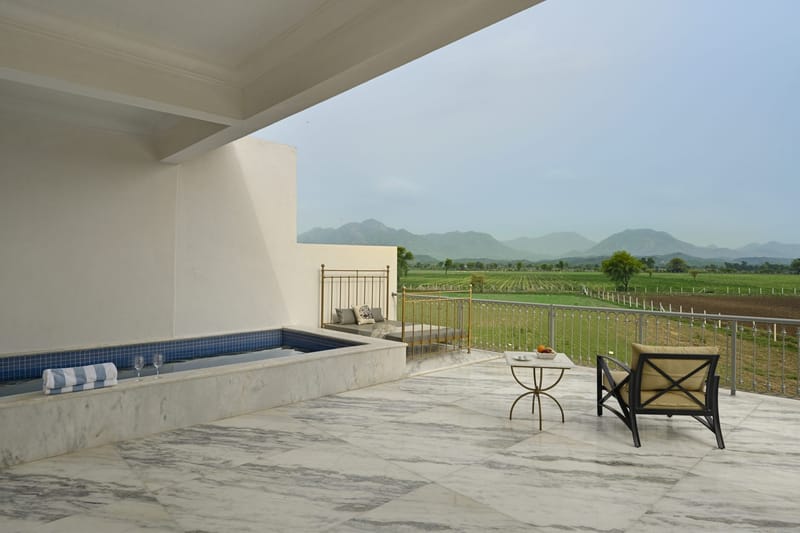 Suite terrace with private plunge pool, daybed, and farmland running to the mountains