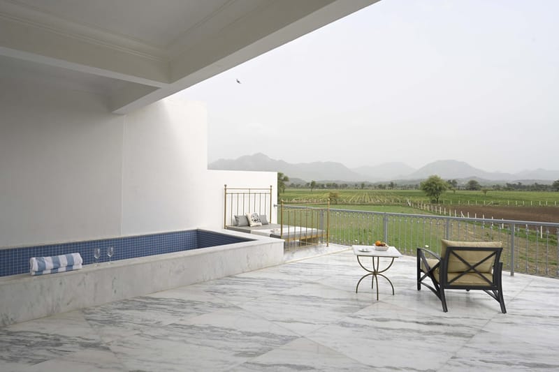 Suite terrace with plunge pool, gold daybed, and fields beyond
