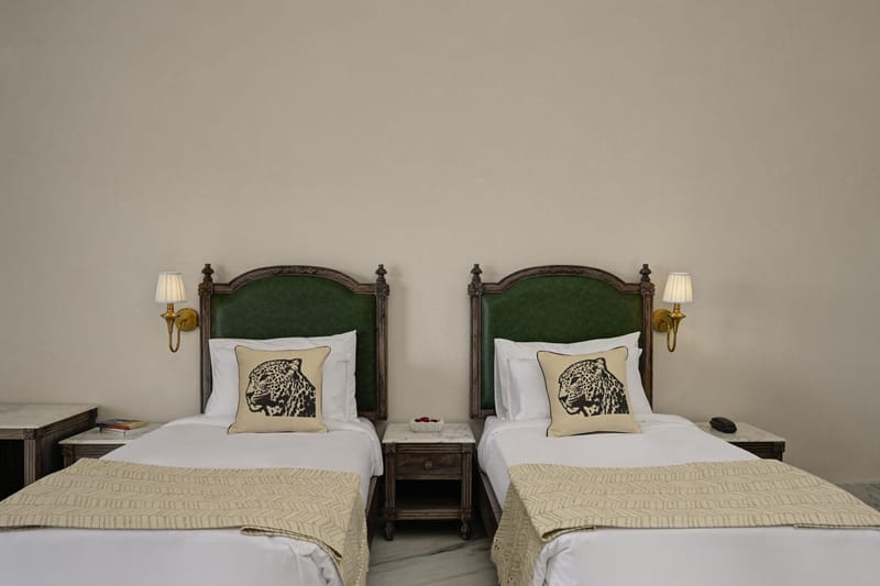 2 single beds with green headboards and leopard-print cushions in a Twin Bed Room