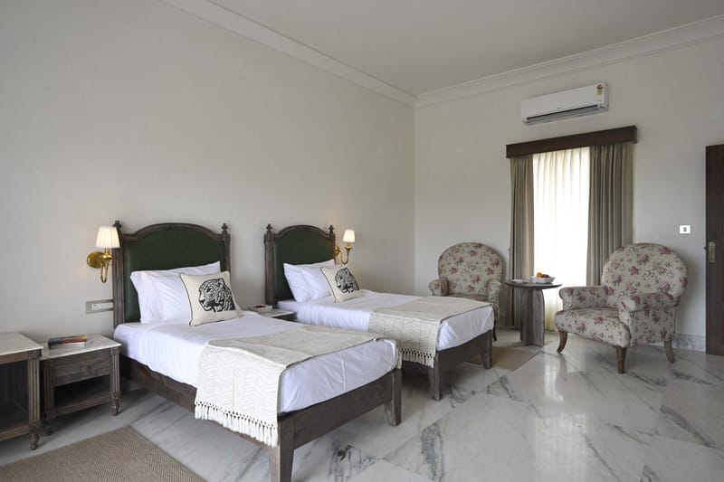 Twin Bed Room with 2 single beds, armchairs, and a wall lamp