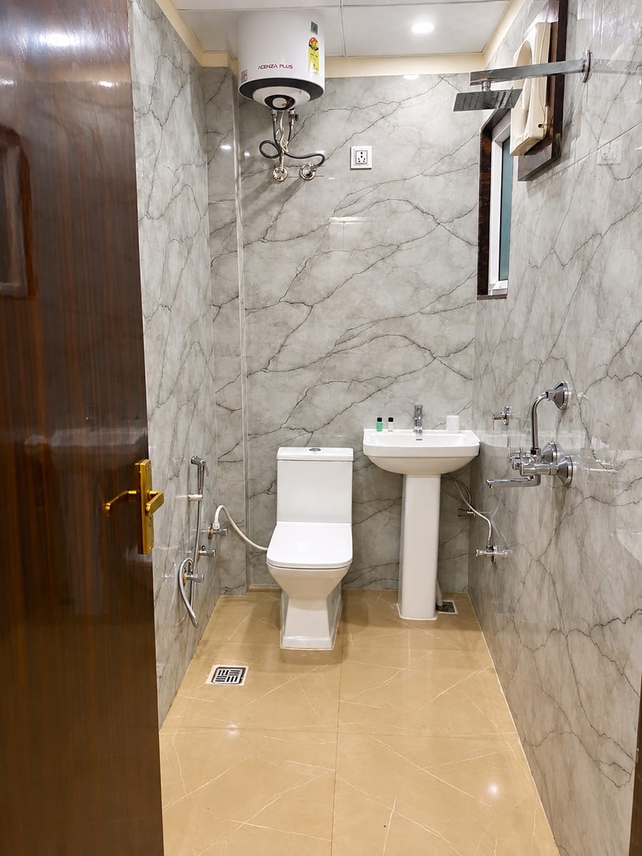 Deluxe Room bathroom with a shower, a wash basin and a water heater at Lime Tree Hotel, Vrindavan